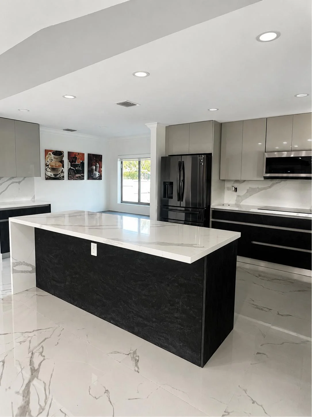 Modern kitchen with black island, white countertops, gray cabinetry, and black stainless appliances